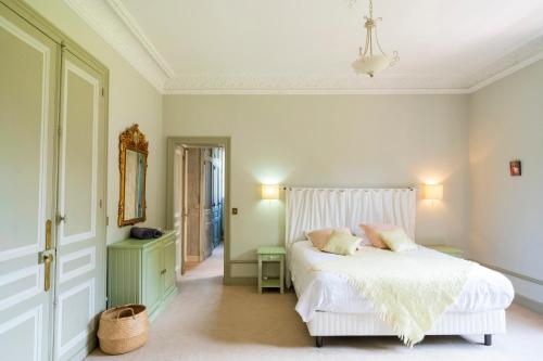 a bedroom with a white bed with pillows on it at Villa d’Exception, Piscine, Parc in Soustons