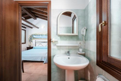 a bathroom with a sink and a bed at Su Birde Agriturismo in Orosei