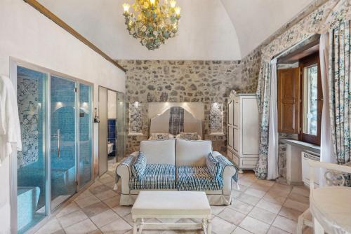 a living room with a couch and a chandelier at Romantico casale di lusso con Spa in Conca dei Marini