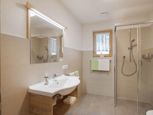 a white bathroom with a sink and a shower at Radlspitz Maurerhof in Valdurna