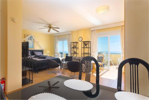 a living room and dining room with a view of the ocean at Villa Roca Penthouse in Estepona
