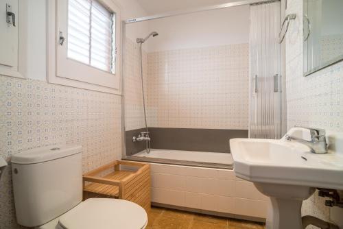 a bathroom with a toilet and a sink and a tub at Canet Beach 1 in Canet de Mar
