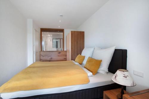 a bedroom with a large bed with yellow pillows at Chalet Foret - Ferienwohnung in Todtnauberg