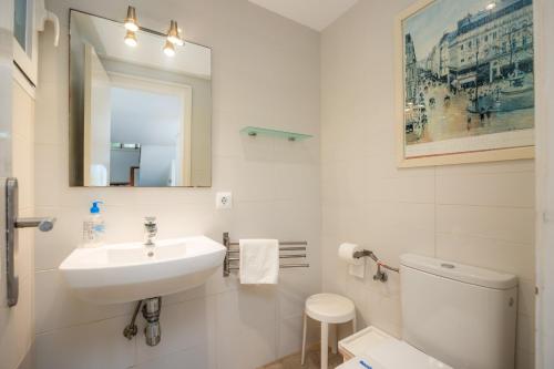 a white bathroom with a sink and a toilet at Can Botana 7 in Cala de Sant Vicenc