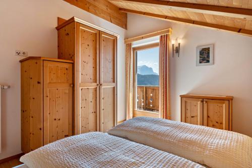 a bedroom with a bed and a window at Haus Alpenblick Apt Edelweiß in Laion