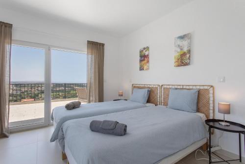 two beds in a white room with a window at Peace House Lourinhã - Villa 8 in Lourinhã
