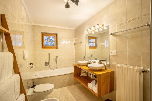 a bathroom with two sinks and a shower and a toilet at Mountain Residence Kasern Nr 1 in Predoi