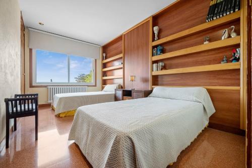a bedroom with two beds and a window at Vila Roser in L'Ametlla de Mar