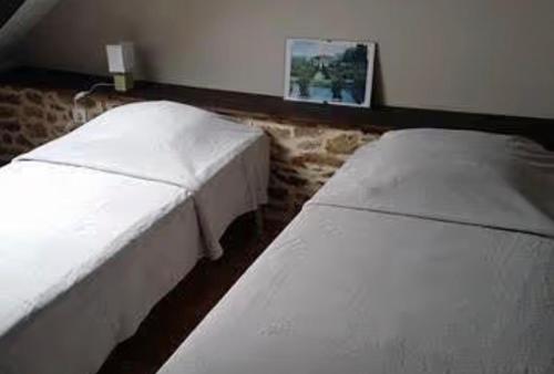 two white beds in a room with a picture on the wall at Gîte Joly in Corseul