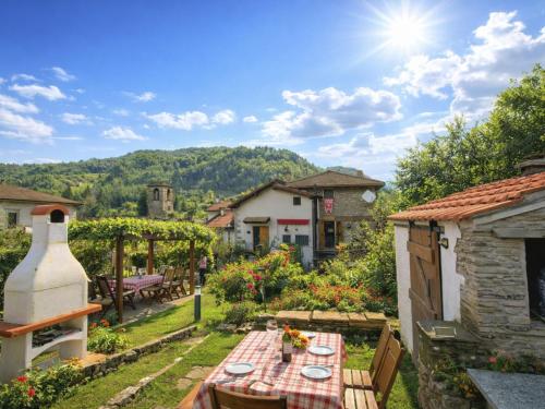 a garden with a table and a view of a house at Apartment Torre by Interhome in Palazzuolo sul Senio
