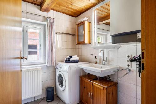 a bathroom with a washing machine and a sink at Fewo Silke Dethlefsen in Pellworm