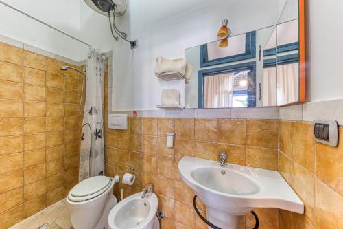 a bathroom with a sink and a toilet and a mirror at Villa Blu La Cambusa in Castro di Lecce