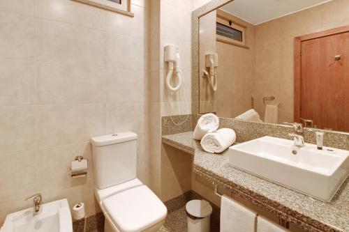 a bathroom with a white toilet and a sink at Dfm Happy Days E - Funchal in Funchal