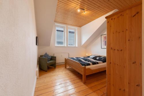 a bedroom with a bed and a chair at Alte Stadtvilla in Neuwied