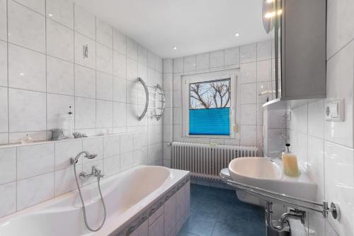 a white bathroom with a tub and a sink at Ferienwohnungen Hog , Ringsheim in Ringsheim