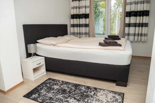 a bedroom with a large bed with white sheets at Villa Nordhang - Apartment 04 in Winterberg