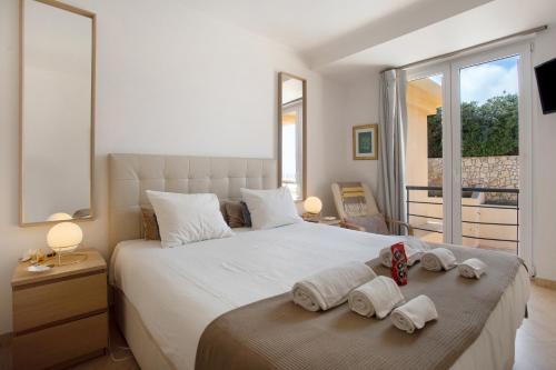 a bedroom with a large white bed with towels on it at Praia Areia Branca in Lourinhã