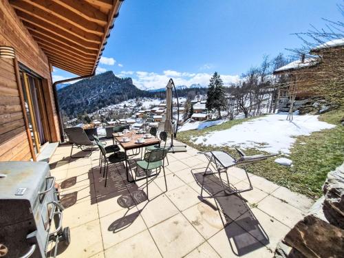 a patio with a table and chairs and an umbrella at Chalet Alpina by Interhome in Ovronnaz
