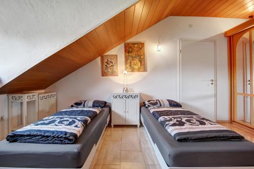 two beds in a room with a attic at Villa Galerie in Hohenwart