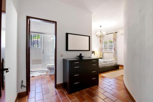 a bathroom with a sink and a toilet and a mirror at Quinta da Violeta in Loulé