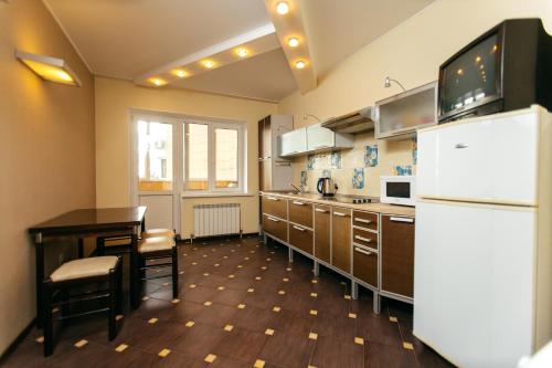 タンボフにあるApartment PrezentHaus Gorkogo 20のキッチン(テーブル、白い冷蔵庫付)