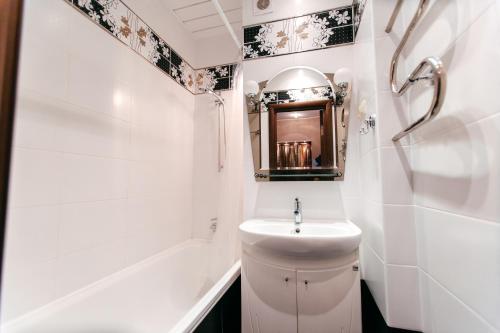 タンボフにあるApartment PrezentHaus Gorkogo 20の白いバスルーム(シンク、鏡付)
