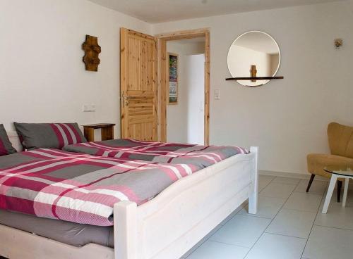a bedroom with a bed and a mirror and a chair at Ferienwohnung Die Schmiede in Schopfloch