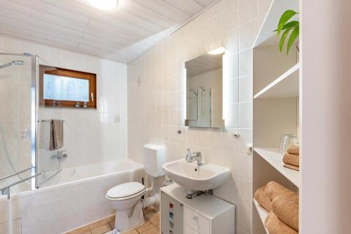 a white bathroom with a sink and a toilet at Ferienwohnung Brigitte in Forbach