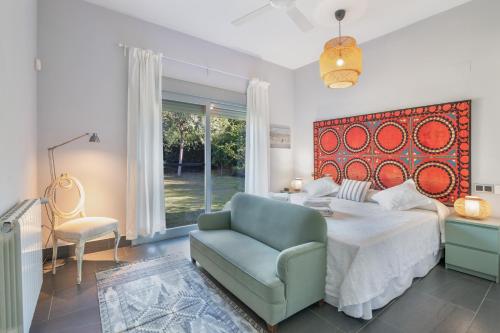 a bedroom with a bed and a couch and a chair at Villa Rompido in Cartaya