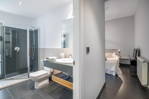 a white bathroom with a toilet and a sink at Villa Rompido in Cartaya