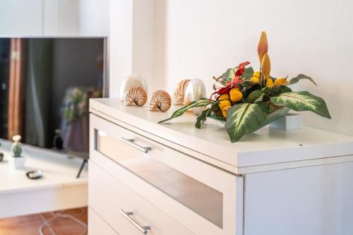 a white dresser with a flower arrangement on it at Santa Eulalia in Can Picafort
