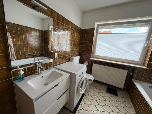 a bathroom with a sink and a toilet and a window at Casa Jo und Jo in Pfullendorf