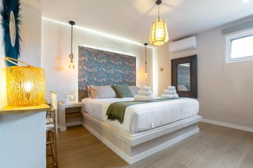 a bedroom with a white bed with a blue painting on the wall at Oceania Villa B, Private Pool in Chayofa