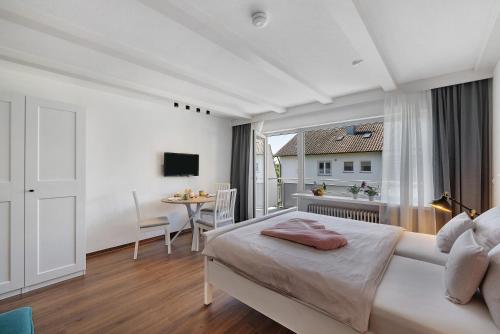 a bedroom with a bed and a table and a window at Andrea in Langenargen