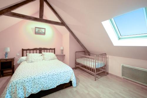 ein Schlafzimmer mit einem Bett und einem Kinderbett in der Unterkunft Gite l'hermine in Cast
