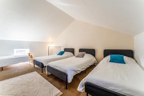 three beds in a room with white walls at Lila Mas in Camaret-sur-Aigues