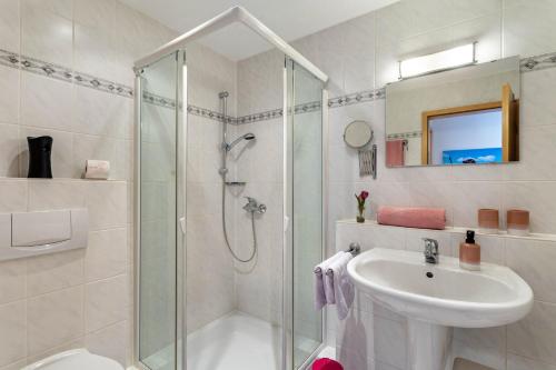 a white bathroom with a shower and a sink at Fewo Willingenliebe Meinecardplus in Willingen