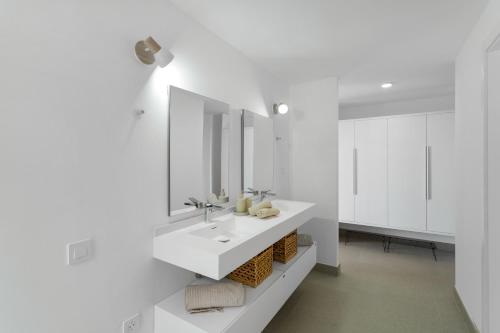 a white bathroom with a sink and a mirror at Yucas Villa 14 in San Bartolomé