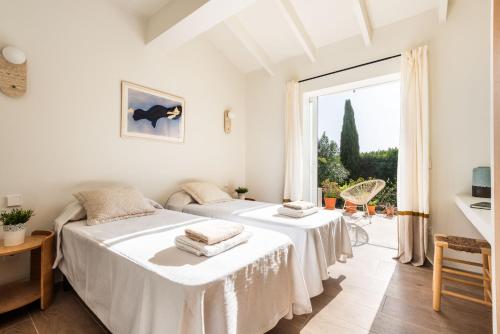 two beds in a room with a window at Horizonte Sur in Binibeca