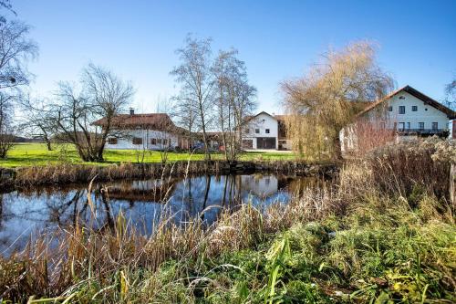 a couple of houses and a pond with houses at Haus am Hof in Kirchseeon