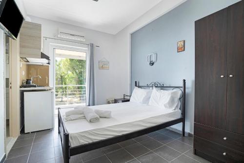 a bedroom with a bed and a kitchen with a window at Iguana studio 7 in Preveza