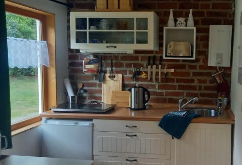 a kitchen with a sink and a brick wall at Seeidyll in Heidesee