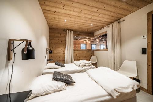 three beds in a room with wooden ceilings at Martonne Terrasse chatel Roca in Châtel