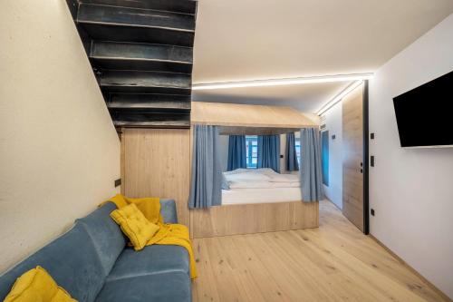 a living room with a blue couch and a bed at Avia Living Maria in Brunico