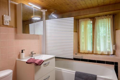 a bathroom with a tub and a sink and a toilet at Gîte De Pipala in Mittlach