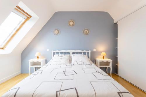a bedroom with a large white bed with two side tables at Maisonette face à la mer in Trégunc