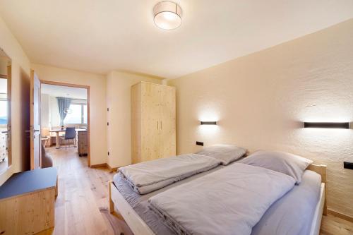 a bedroom with a large bed with white sheets at Hauserhof in Lagundo