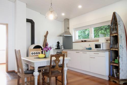 a kitchen with white cabinets and a table and chairs at Gästehäusle Haag in Waldshut-Tiengen