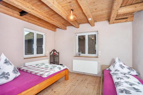 a bedroom with two beds and a wooden ceiling at Salerhof in Bad Wurzach