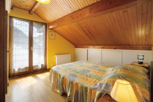 a bedroom with a bed and a large window at La Grange Villard in Albiez-Montrond